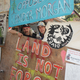 Two protestors, Black Wolf (left) and Xenoa Skinieth, stand among protest signs near the Kinder Morgan oil facility in Vancouver, Canada.